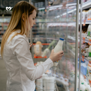 Beautiful woman buying milk in the supermarket